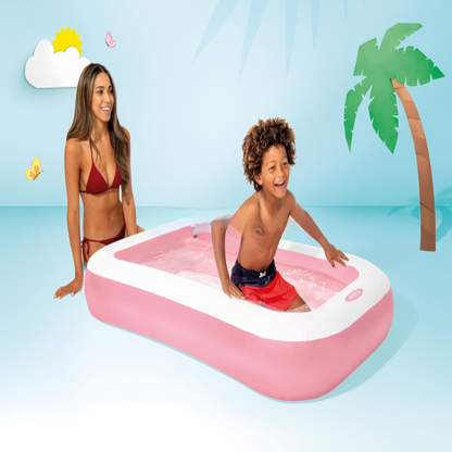 Woman and child playing on a pink inflatable pool toy with a palm tree and sun in the background