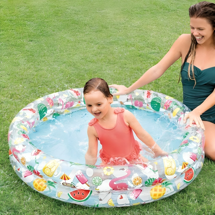 Child playing in an inflatable pool with a woman on grass