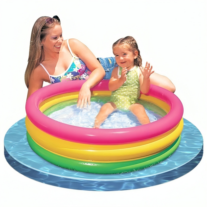Inflatable pool with colorful rings and a woman and child playing inside.